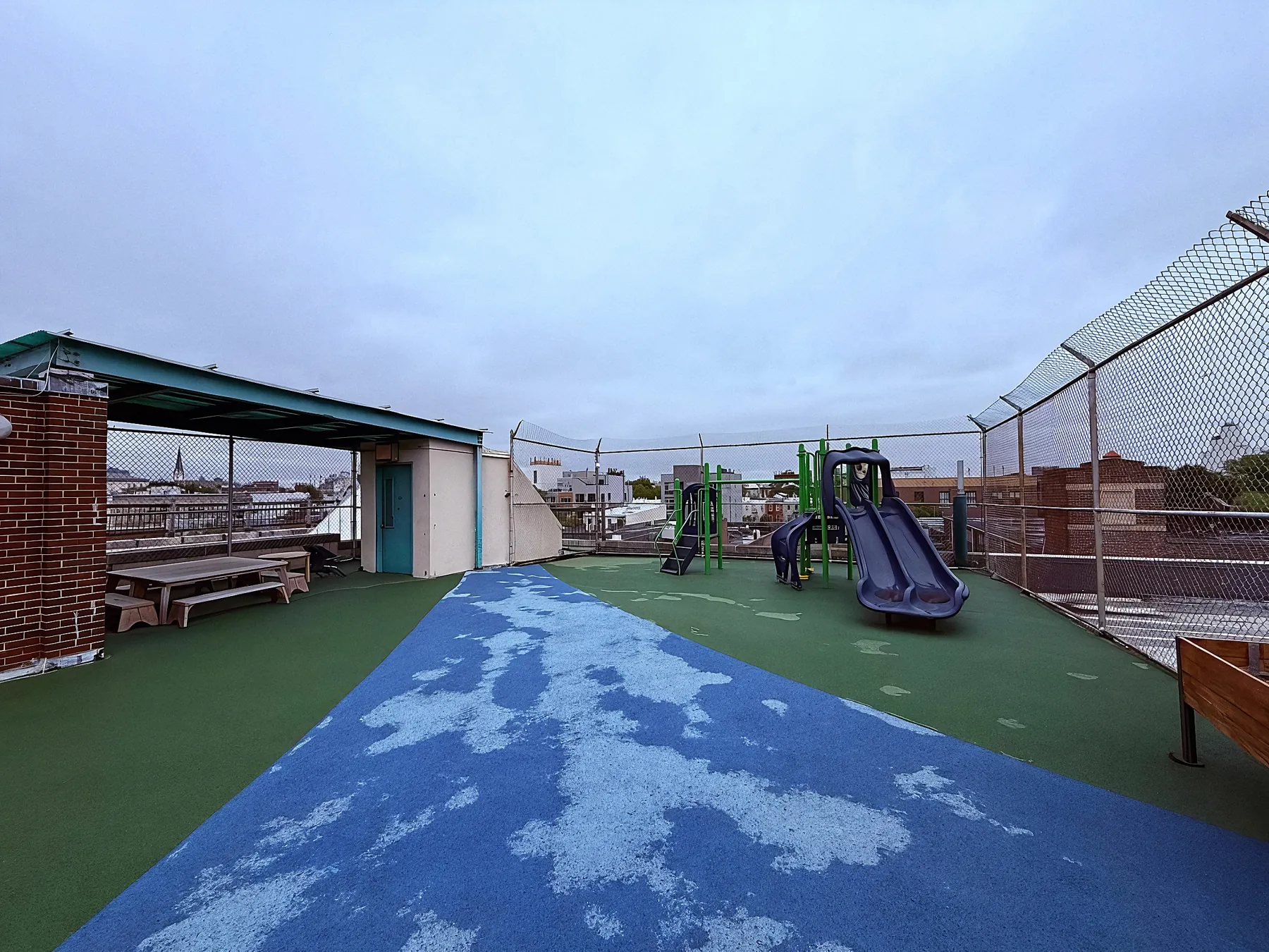 The open rooftop of the school above Greenpoint, with the neighborhood on the horizon